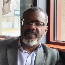Bekley Wendell Semple wearing a grey suit jacket and glasses