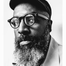 roger robinson wearing a cap and glasses